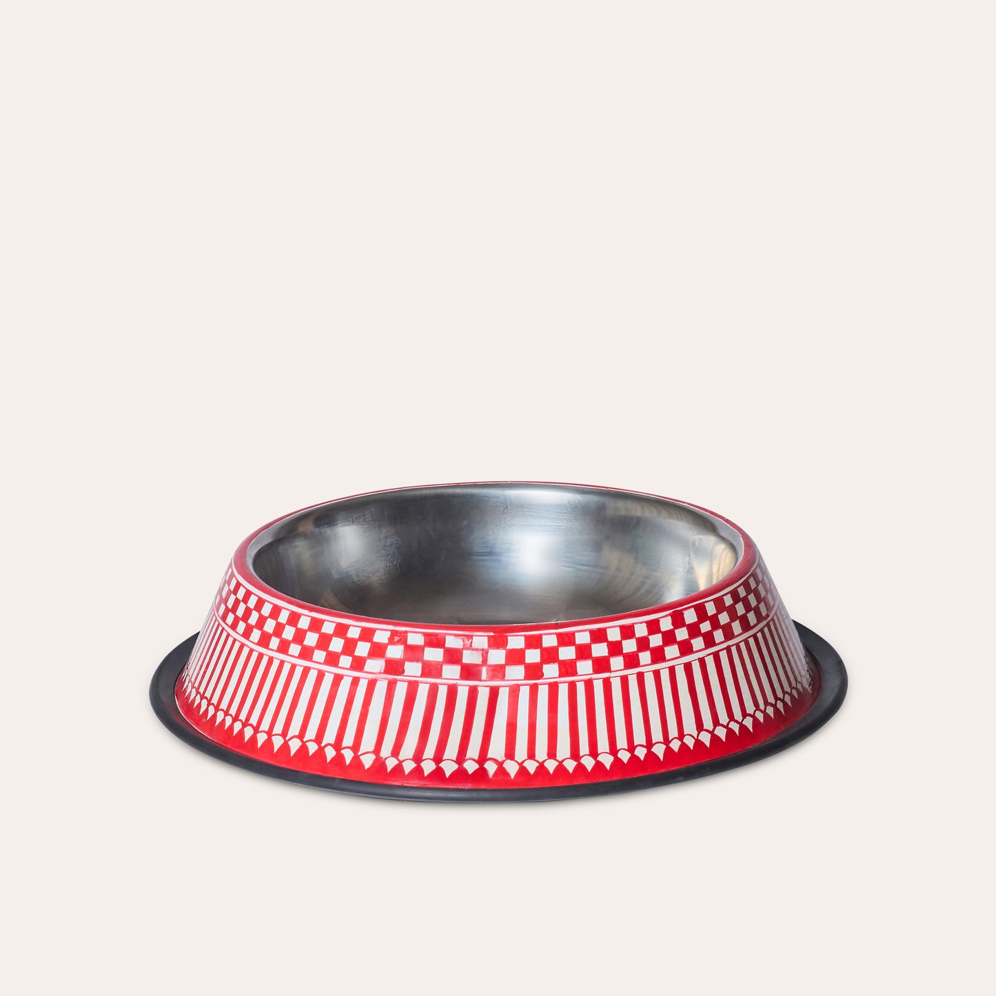 Stainless steel metal pet water bowl with red and white checkered pattern painted outside on a light beige background.