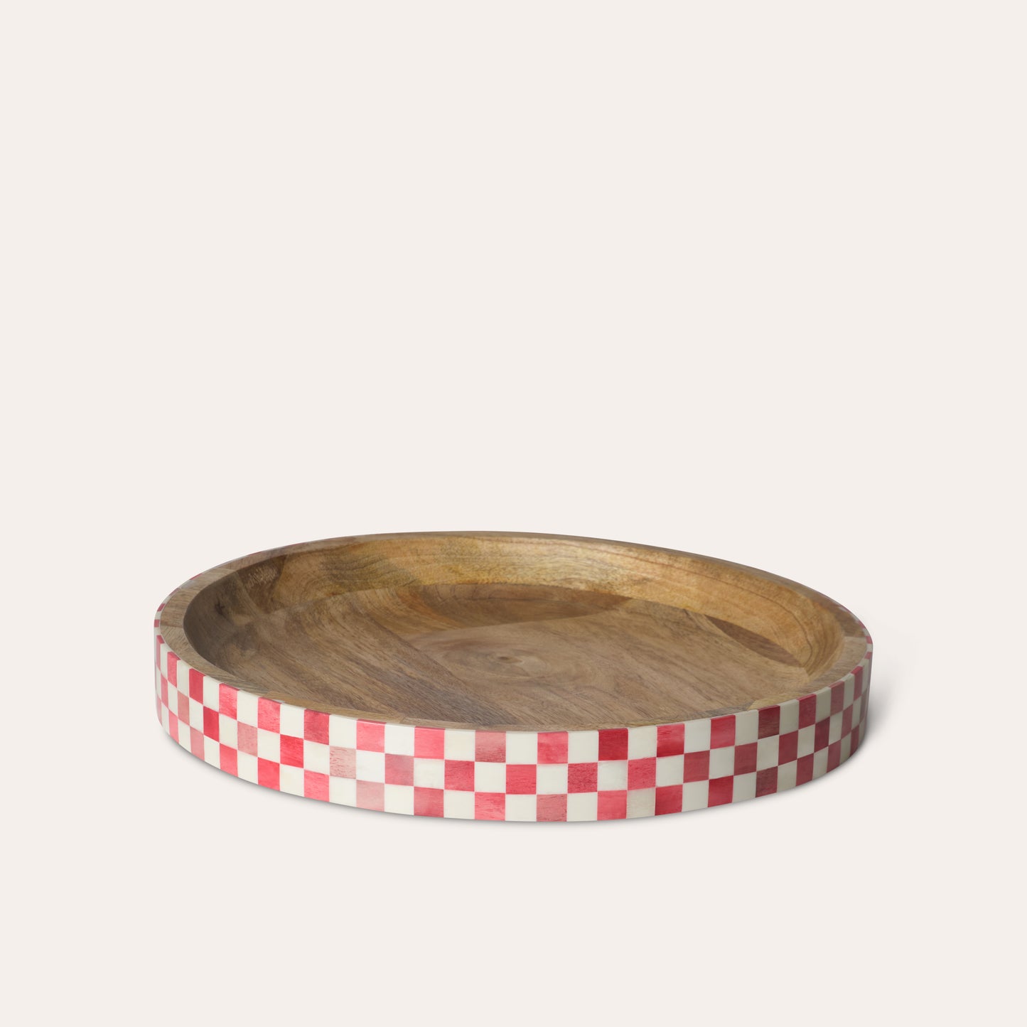 Round circular wooden tray with a red and white checkered edge on a beige background.