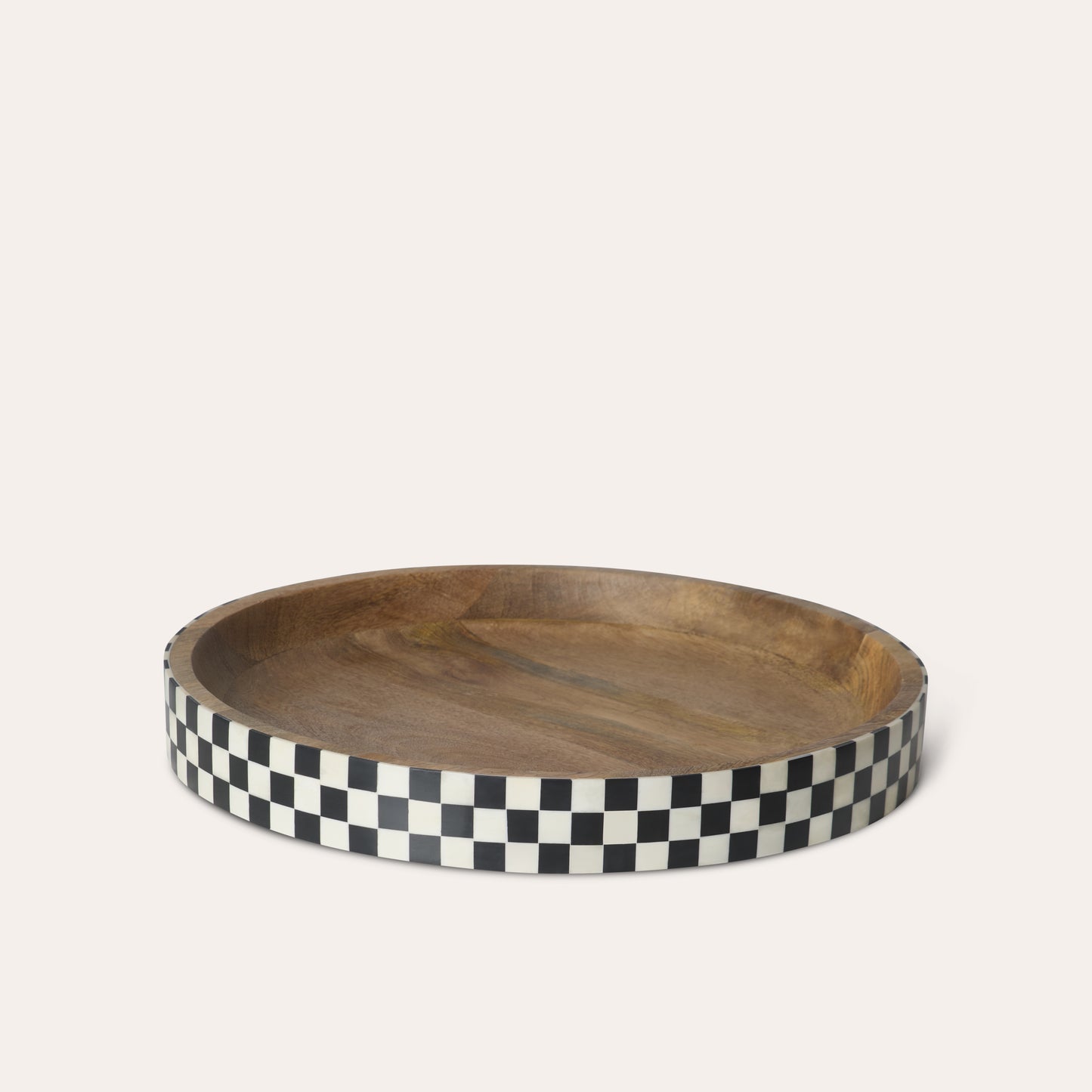 Circle round wooden tray with a black and white checkered border on a white background.