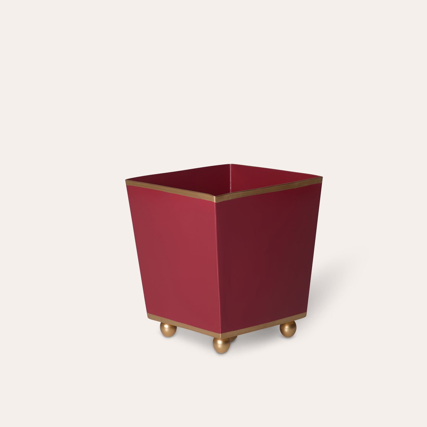 Red cube planter with gold trim and feet on a white background