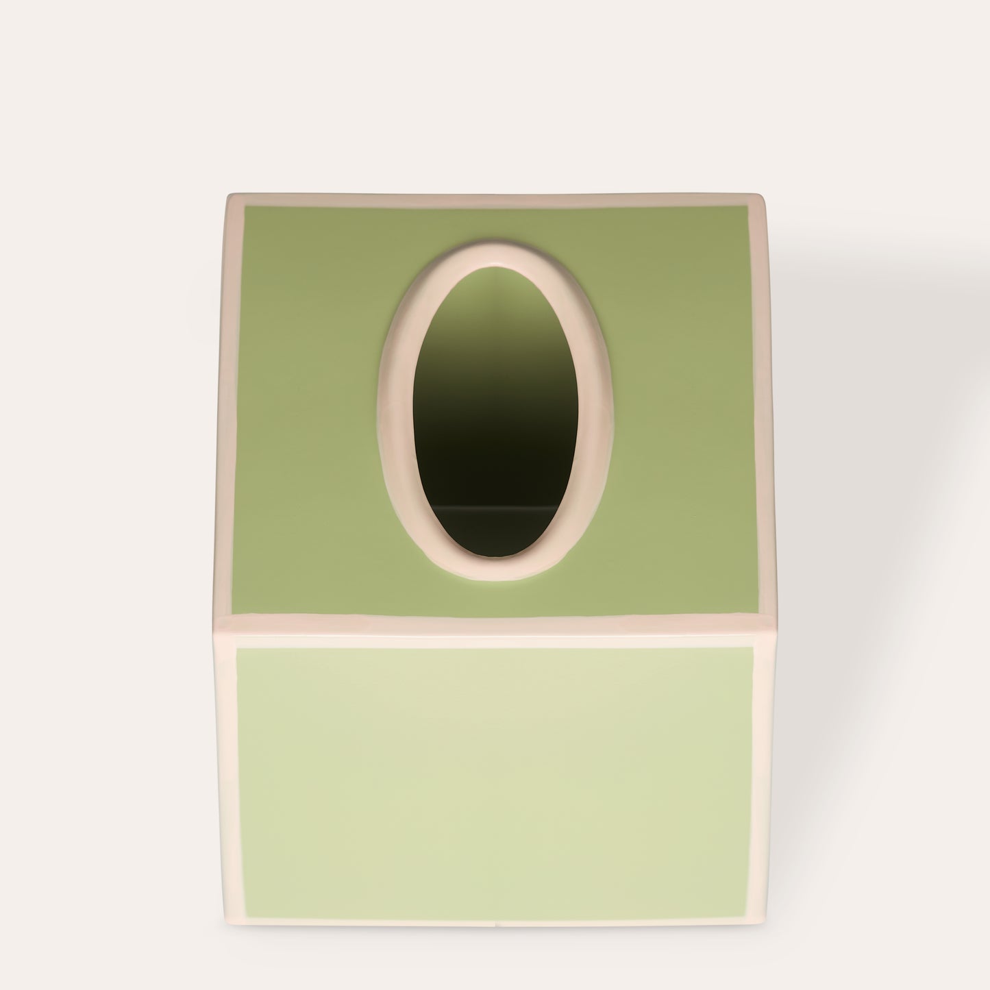 Green tissue paper cover box with beige pink edges on a white background.