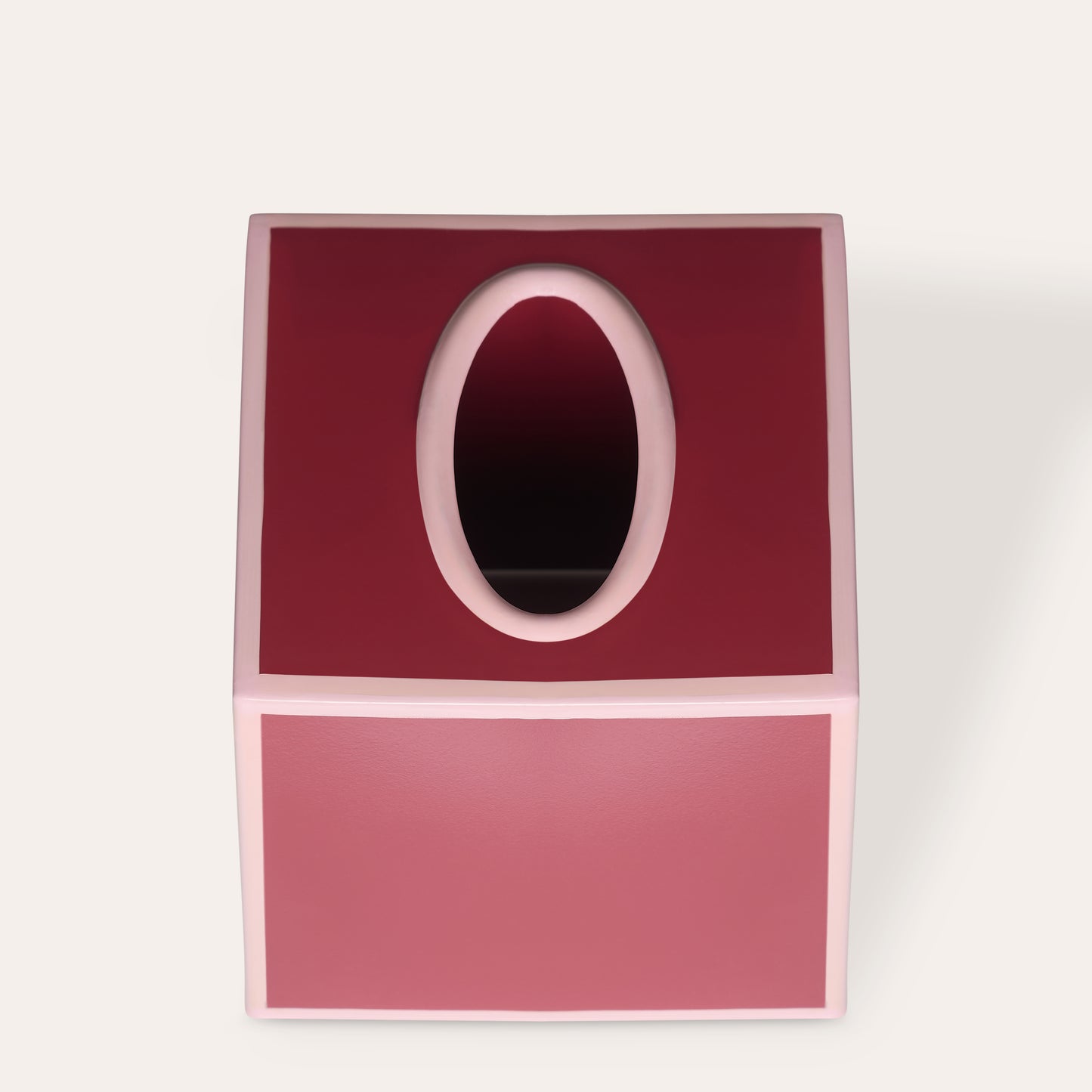 Red square tissue paper box cover with an oval opening on top and pink edges on a white background.