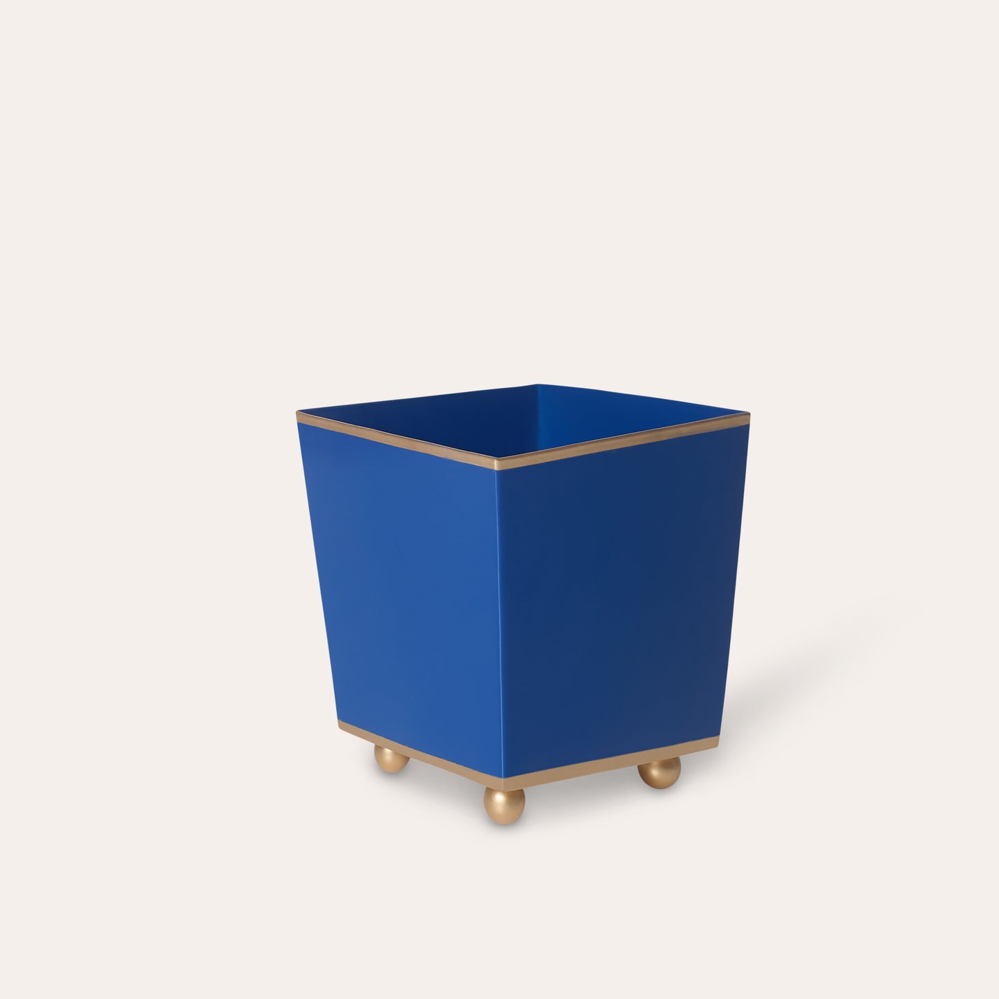 Blue cube planter with gold rim and feet on a white background
