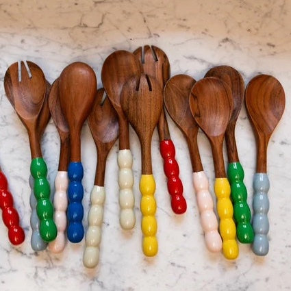 A collection of serving spoons with colourful bobbin handles made of mango wood.