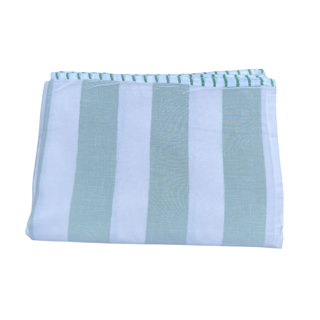 Folded striped cotton blanket in green and white stripes with a decorative stitched edge.