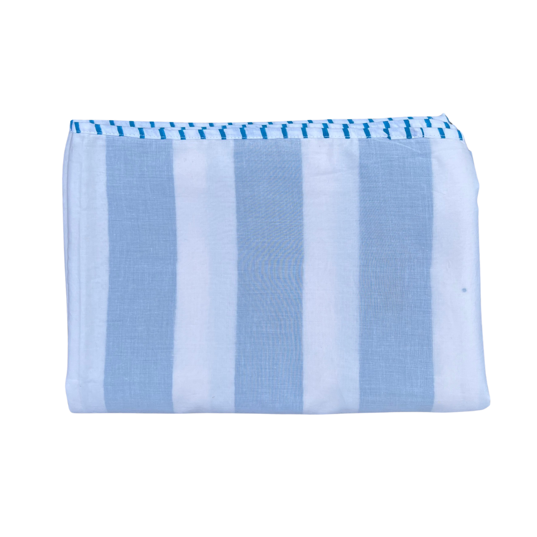 Folded striped cotton blanket in blue and white stripes with a decorative stitched edge trim in the same colour.