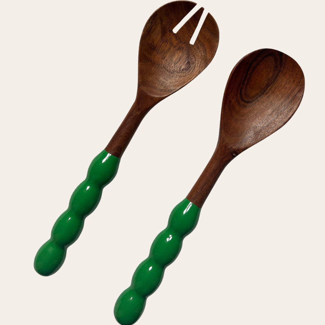 Wooden salad servers with green handles on a white background