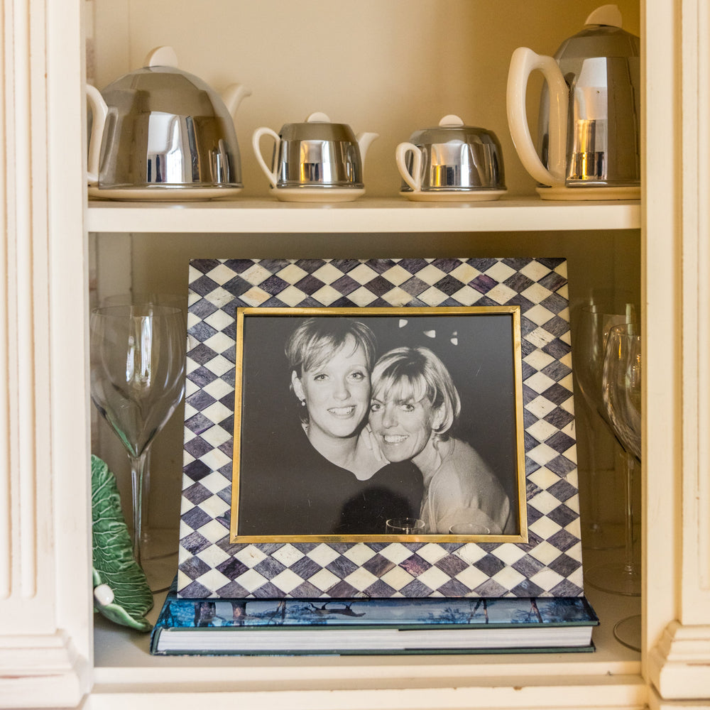 Cabinet with silver teapots, a framed photograph, and decorative items.
