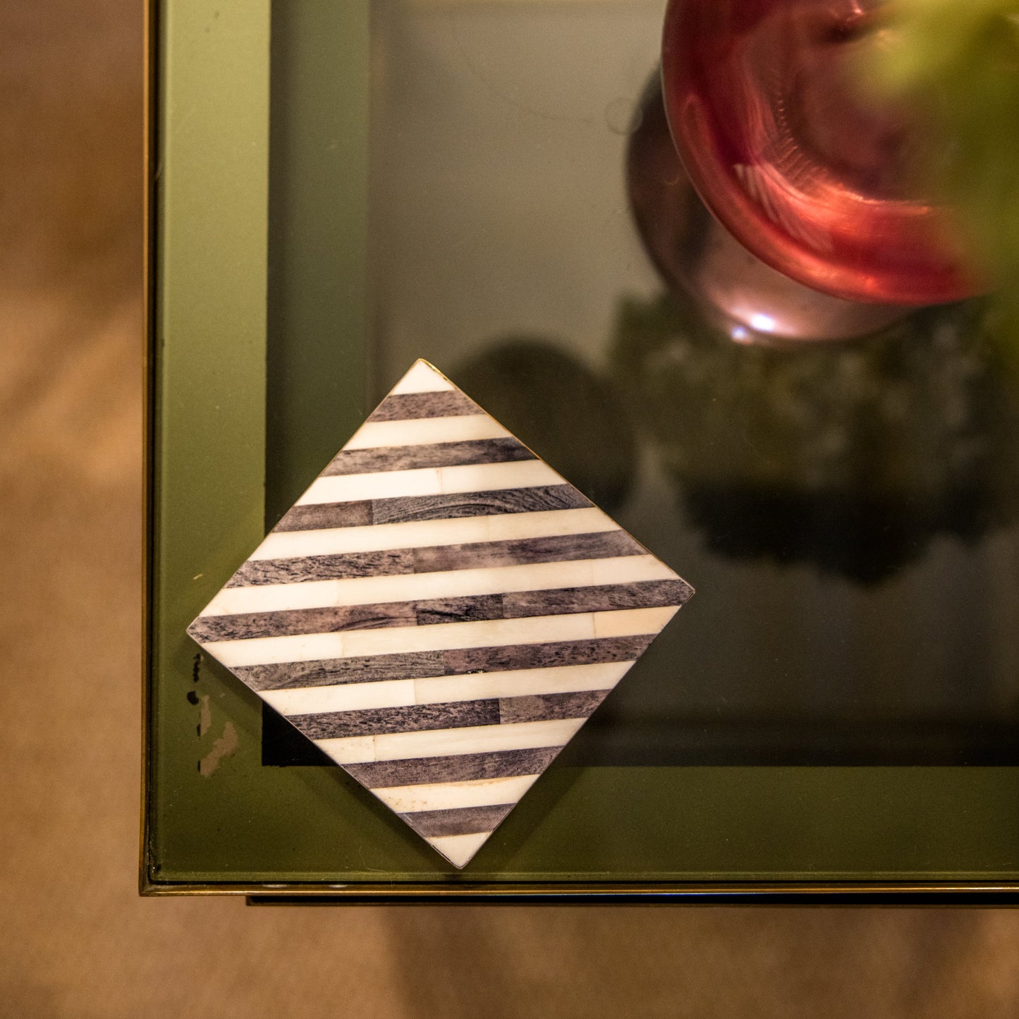 Decorative item with striped pattern on a reflective surface