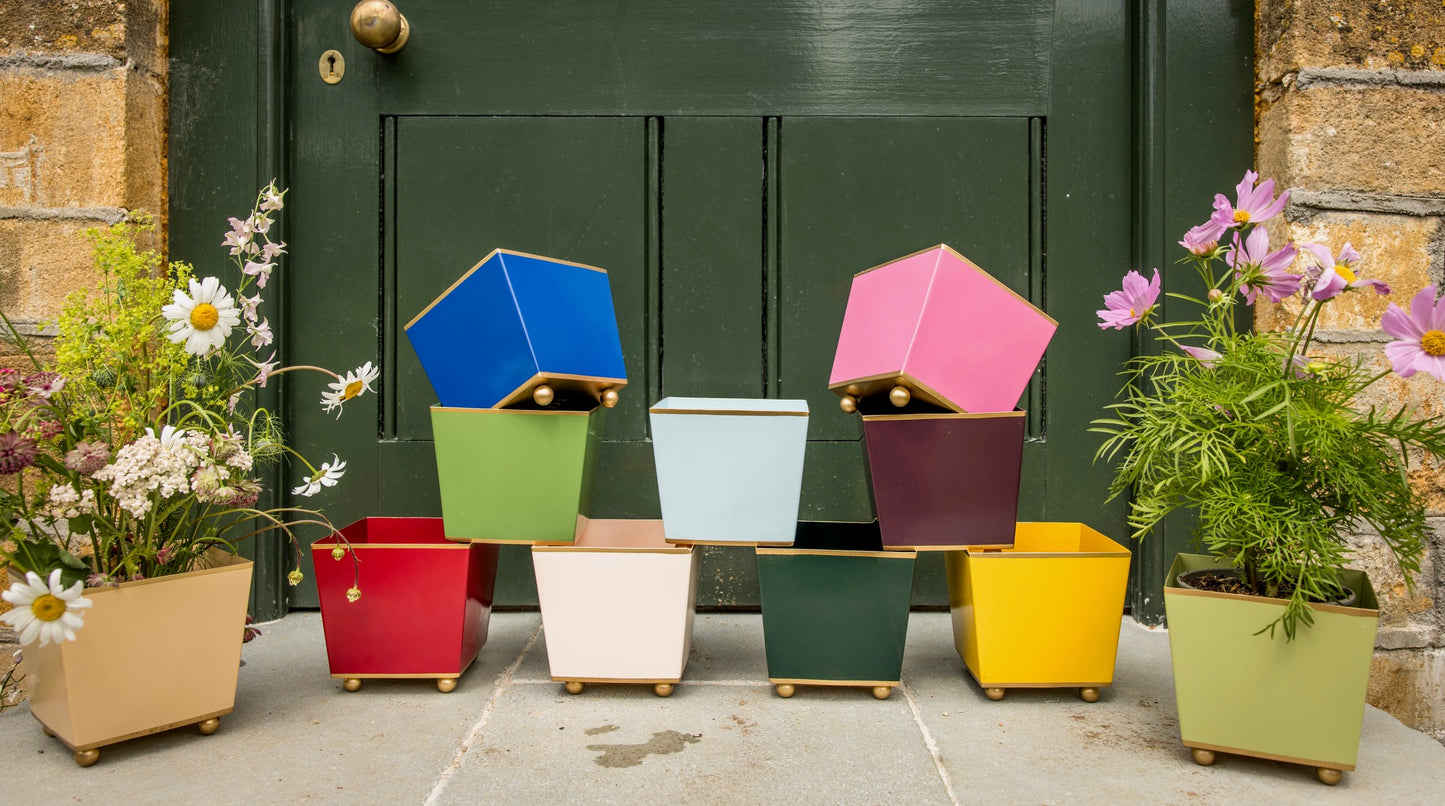 Colorful geometric planters in front of a green door.