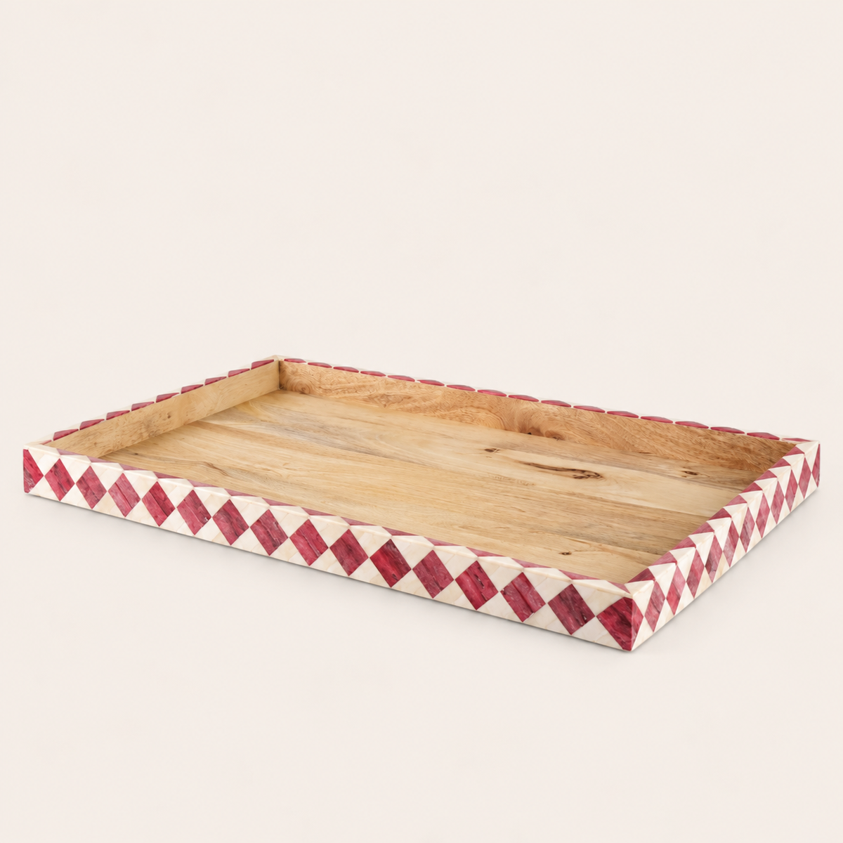 A rectangular wooden serving tray with a natural wood grain interior and a border decorated with a red and white diamond inlay pattern, shown on a light beige background.