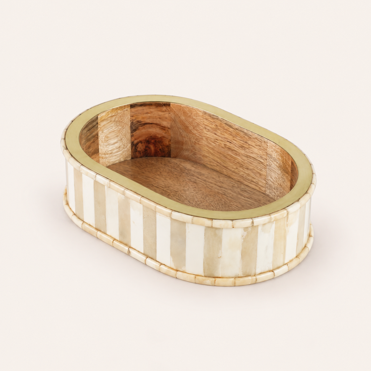 An oval-shaped decorative box featuring a striped pattern of cream bone inlay and light wood on the exterior, with a smooth medium-brown wood interior and a polished gold-toned rim, set against a solid off-white background.