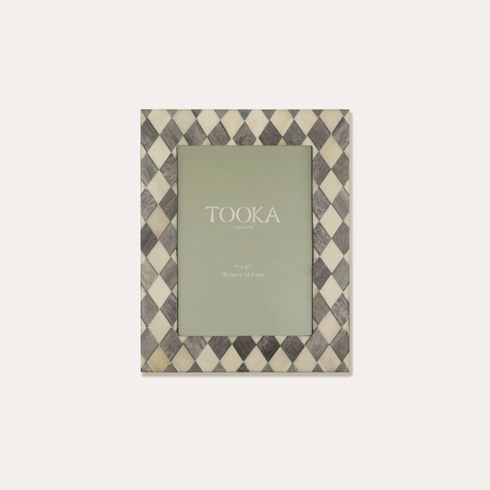 Checkered photo frame with a green card inside on a white background