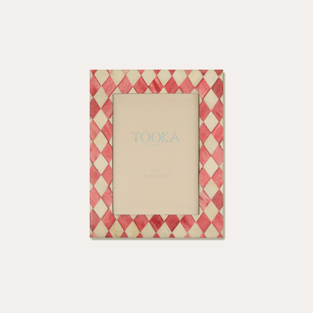 Decorative picture frame with a red and beige checkered pattern on a white background
